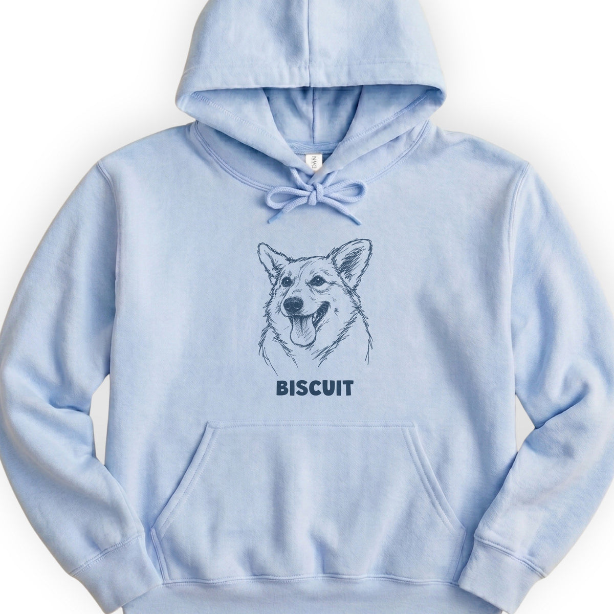 The Portrait Hoodie in Light Blue with a portrait of a corgi and the name Biscuit