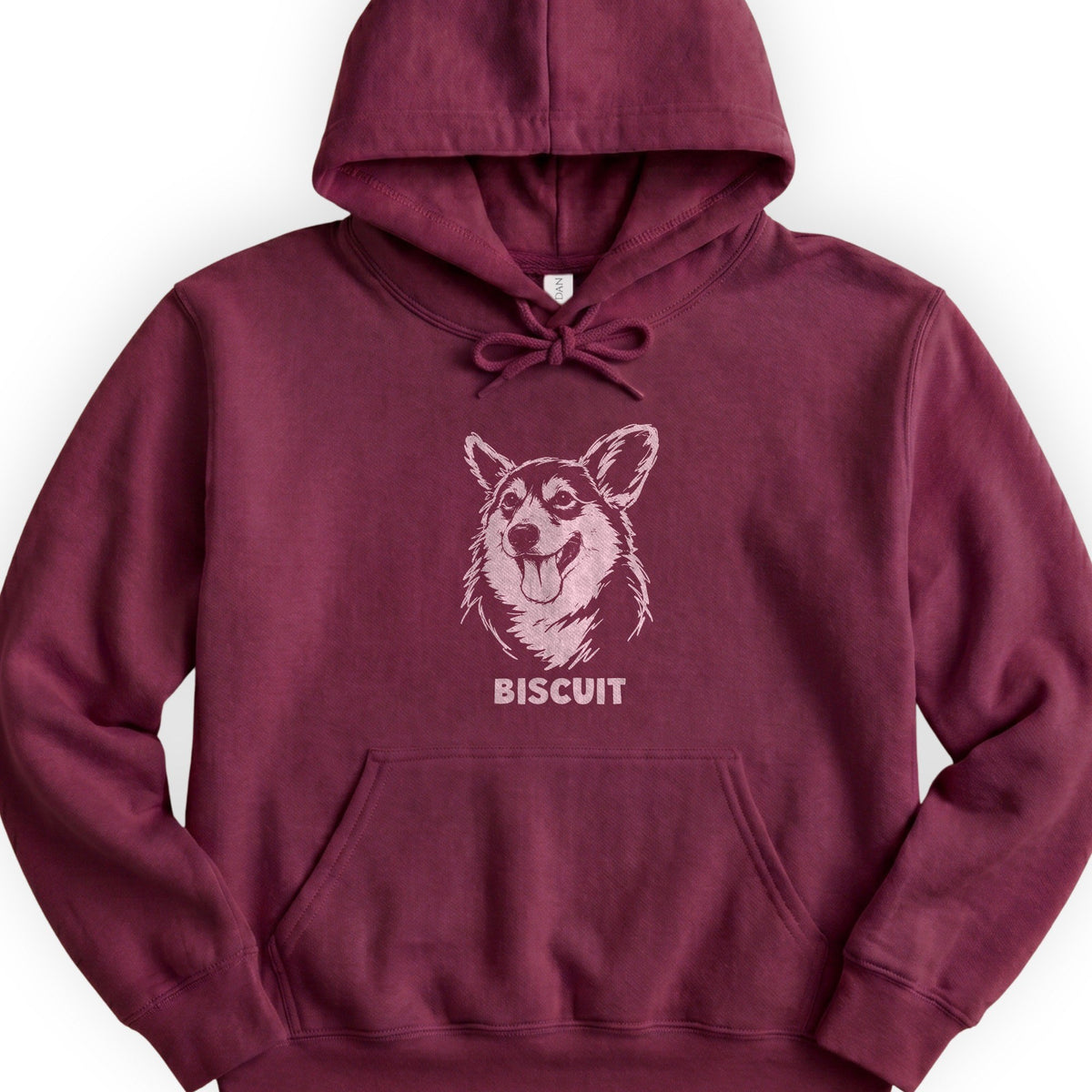 The Portrait Hoodie in Maroon with a portrait of a corgi and the name Biscuit