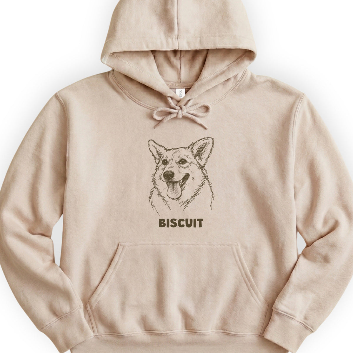 The Portrait Hoodie in Sand with a portrait of a corgi and the name Biscuit
